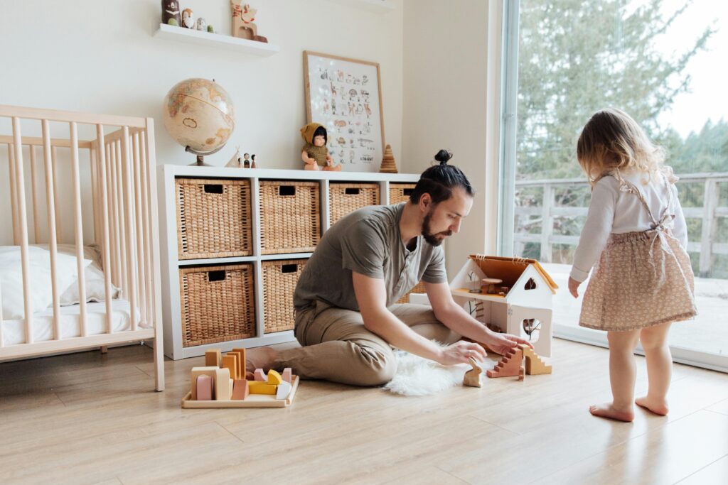 Dad putting his children's toys away in a play room